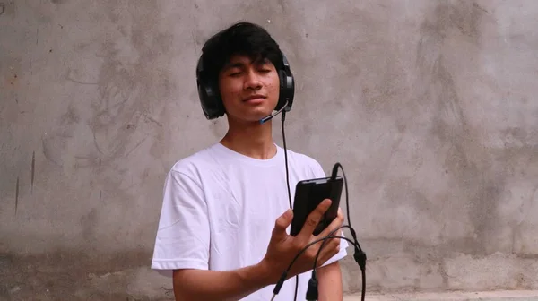 Ázsiai Férfi Használ Smartphone Headset Hallgatni Dal — Stock Fotó