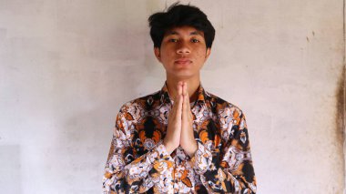 Tipik Endonezya Batik giysileri giyen Asyalı bir adamın ifadesi.        