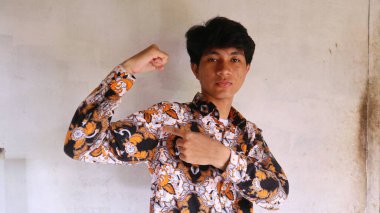 Tipik bir Endonezya batik tişörtü giyen Asyalı bir adamın ifadesi. Batik kullanma konusunda hevesli                       