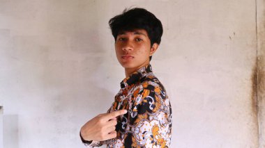 Tipik Endonezya Batik giysileri giyen Asyalı bir adamın ifadesi.        