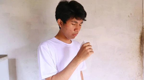 白いTシャツのアジア人男性が咳をしている — ストック写真