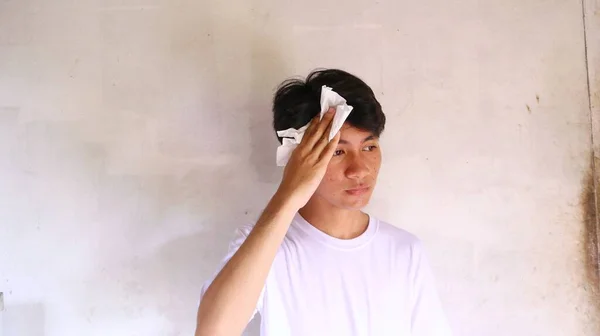 Beyaz Tişörtlü Asyalı Bir Adam Yüzünü Mendille Siliyor — Stok fotoğraf