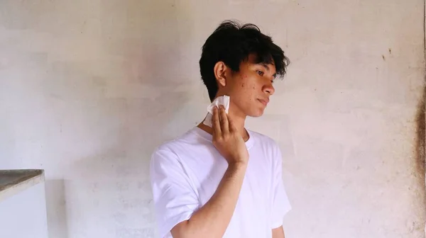 Beyaz Tişörtlü Asyalı Bir Adam Yüzünü Mendille Siliyor — Stok fotoğraf