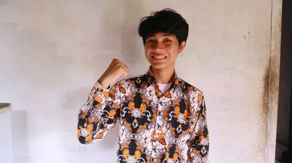 一个亚洲男人穿着典型的印尼蜡染衬衫 自豪的表情 热衷于使用蜡染 — 图库照片