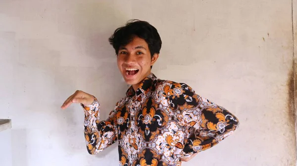 一个身穿典型的印尼蜡染衬衫的亚洲人的表情很滑稽 — 图库照片