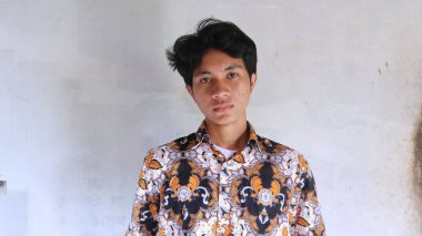 Tipik Endonezya Batik giysileri giyen Asyalı bir adamın ifadesi.        