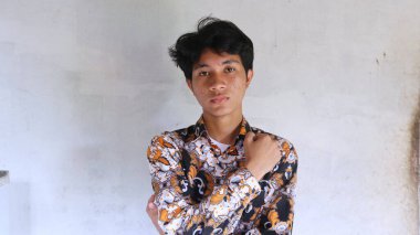 Tipik Endonezya Batik giysileri giyen Asyalı bir adamın ifadesi.        