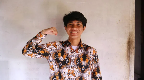 一个亚洲男人穿着典型的印尼蜡染衬衫 自豪的表情 热衷于使用蜡染 — 图库照片