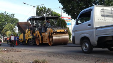 Bengkulu, Endonezya. 28 Mayıs 2023: Bengkulu karayolu hibrit yolundaki asfaltı düzleştirme, asfaltlama ve onarma ağır ekipmanları