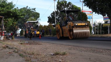Bengkulu, Endonezya. 28 Mayıs 2023: Bengkulu karayolu hibrit yolundaki asfaltı düzleştirme, asfaltlama ve onarma ağır ekipmanları