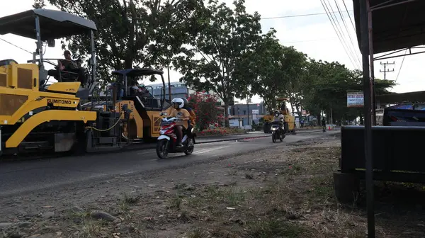 stock image Bengkulu, Indonesia. 28 May 2023: heavy equipment is leveling, asphalting, repairing asphalt on the Bengkulu highway hybrid road