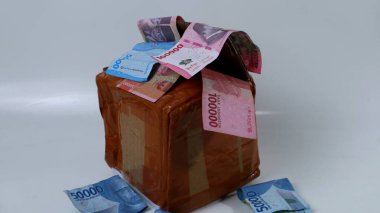 Paketin yanında bir sürü para olan paket alışverişi konsepti, alışveriş, tasarruf, beyaz arka plana yatırım