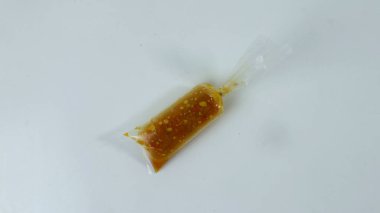 Beyaz arka planda bir paket kırmızı biber sosu