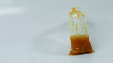 Beyaz arka planda bir paket kırmızı biber sosu