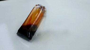 Beyaz arka planda bir paket soya sosu.