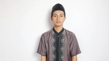 Asyalı Müslüman adam beyaz arka planda gülümsüyor.