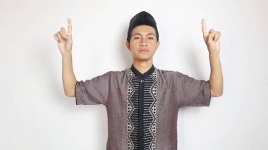 Asyalı Müslüman bir adam beyaz bir arkaplanda işaret ediyor.