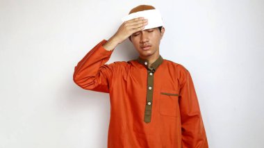 Asyalı Müslüman adam hasta ve beyaz arka planda doku kullanıyor.