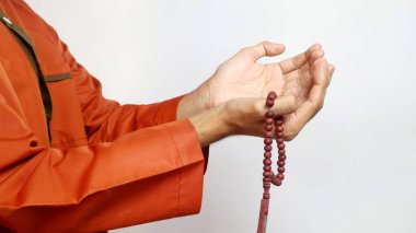 Asyalı Müslüman adamın elleri beyaz arka planda dua ediyor.
