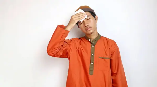asian muslim man is sick and using tissue on white background