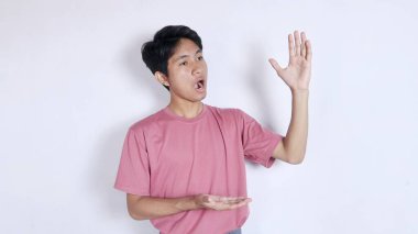 Heyecanlı genç bir adam sunar ve beyaz arka planda izole edilmiş fotokopi alanını gösterir.