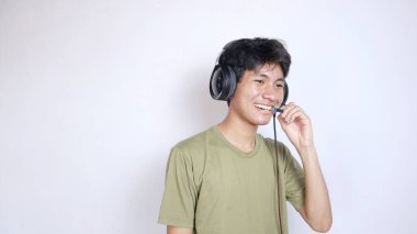 Asyalı adam müzik dinlemek ve iletişim kurmak için kulaklık kullanıyor.