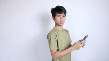 İzole edilmiş beyaz arka planda akıllı telefonla oynayan Asyalı bir adam