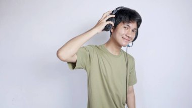 Asyalı adam müzik dinlemek ve iletişim kurmak için kulaklık kullanıyor.