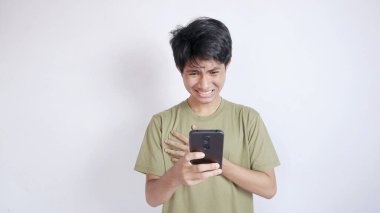 Şaşırmış Asyalı adam ekranda akıllı telefondan izole edilmiş beyaz arka plana bakıyor