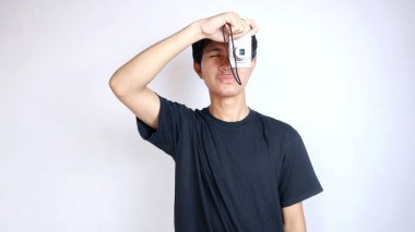 Yakından çekilen yakışıklı Asyalı adam, izole edilmiş beyaz arkaplan ve selfie ile el kol hareketi yapıyor.