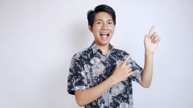 Heyecanlı genç yakışıklı Asyalı adam iki eliyle yukarıya bakıyor izole edilmiş beyaz bir arka planda