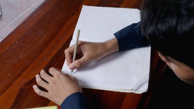 Masaya el yazısıyla kitap yazmak.