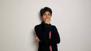 Yakışıklı Asyalı adam gülümsüyor ve mutlu, havalı siyah bir ceket giyiyor, rahat, karizmatik, izole beyaz bir arka planda kameraya bakıyor.