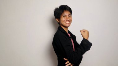 Yakışıklı Asyalı adam gülümsüyor ve mutlu, havalı siyah bir ceket giyiyor, rahat, karizmatik, izole beyaz bir arka planda kameraya bakıyor.