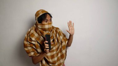 Endonezyalı bir hırsız, beyaz arka planı olan bir akıllı telefonu alırken yakalandı.