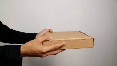 İzole edilmiş beyaz bir arkaplanda bir paket tutan bir adam.