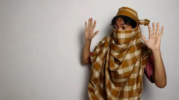 stock image The thief from Indonesia wore a sarong face covering and could not be recognized on a white background