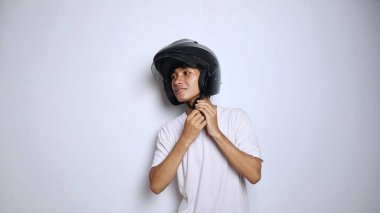 Beyaz gömlekli genç Asyalı adam izole edilmiş beyaz bir arka planda miğfer kullanıyor.