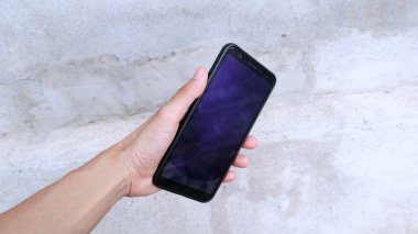 Cep telefonu tutan bir el.