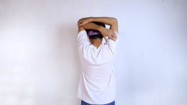 Beyaz gömlekli genç adam spor için ısınıyor, eller ve kollar, izole edilmiş beyaz bir arka plan.