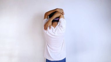 Beyaz gömlekli genç adam spor için ısınıyor, eller ve kollar, izole edilmiş beyaz bir arka plan.