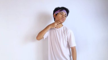 Beyaz gömlekli genç adam, sporu kafasında ısıtıyor ve beyaz bir arka planı var.