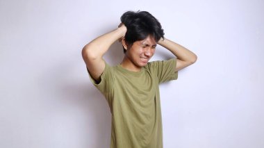 Asyalı genç adam stresli, depresif, baş döndürücü, kafası izole edilmiş beyaz arka planlı.