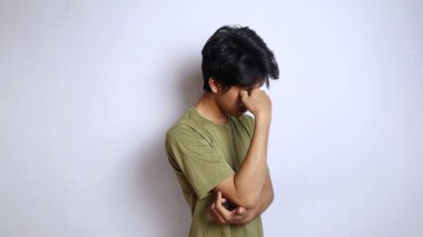 Genç Asyalı adam yorgun el hareketleriyle destek veriyor. Beyaz arka planda kafa kafaya.