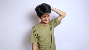 Asyalı genç adam stresli, depresif, baş döndürücü, kafası izole edilmiş beyaz arka planlı.