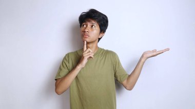 Asyalı genç bir adamın ifadesi, bir jest düşünüyor ve beyaz arka planı olan bir el hareketi yapıyor.
