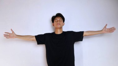 Siyah tişörtlü yakışıklı genç Asyalı adam elini izole edilmiş beyaz arka plana koydu. kopyalama alanı, başarı, mutluluk