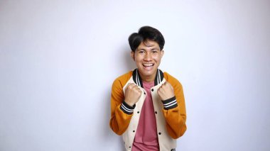 Çekici, yakışıklı, ceketli genç bir adam izole edilmiş beyaz arka planda hevesle el kol hareketi yapıyor.