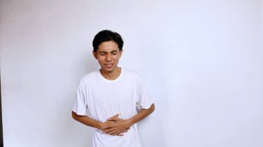 Genç Asyalı adam midesi bulanan beyaz gömlekli el hareketi midesi izole edilmiş beyaz arka plan, kopyalama alanı.