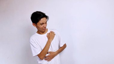 Asyalı genç adam beyaz gömlekli jestlerle kaşındırıyor.